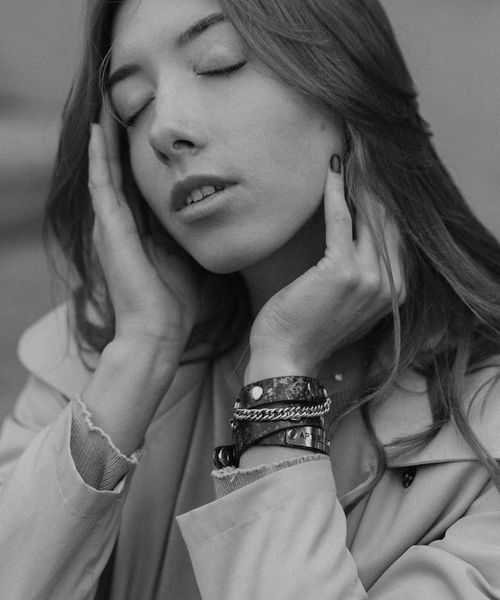 Woman in a calm yoga pose in a dark room with cyan light.
